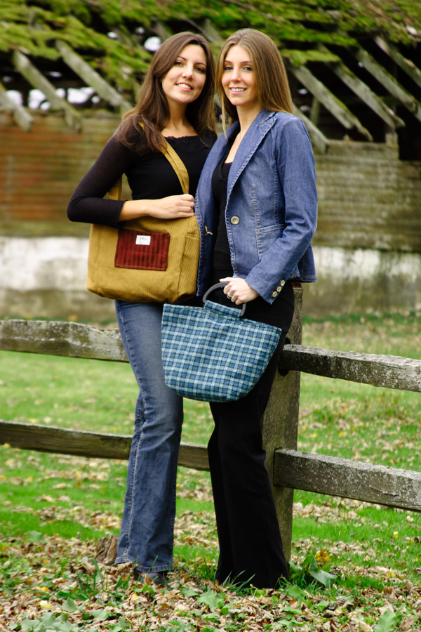 Photo of two girls posing with purses on a farm up against the fence